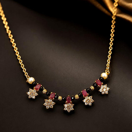 Gold-toned mangalsutra with clear-stone floral clusters, ruby-toned accents and black beads, front view