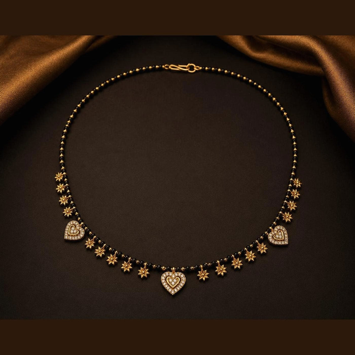 Black bead mangalsutra with clear-stone heart motifs and star accents, front view