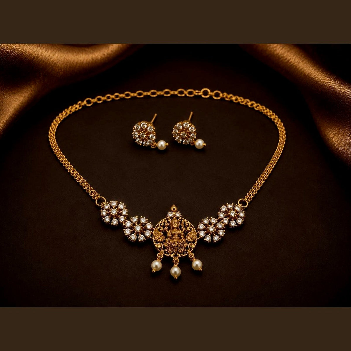 Temple necklace set with a Lakshmi centrepiece, clear-stone clusters and matching earrings, front view