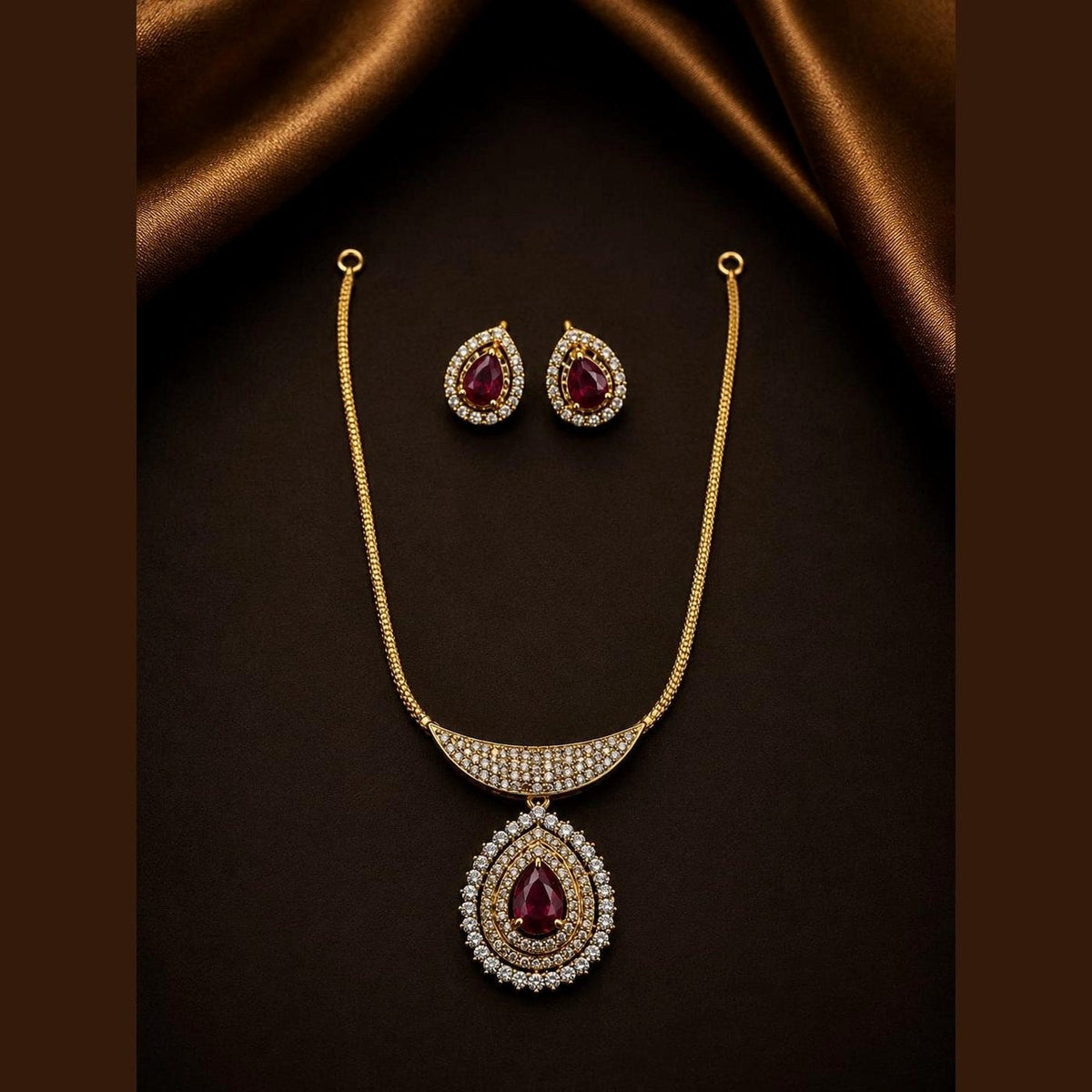 Necklace set with ruby-toned teardrops framed by clear-stone halos, with matching earrings, front view